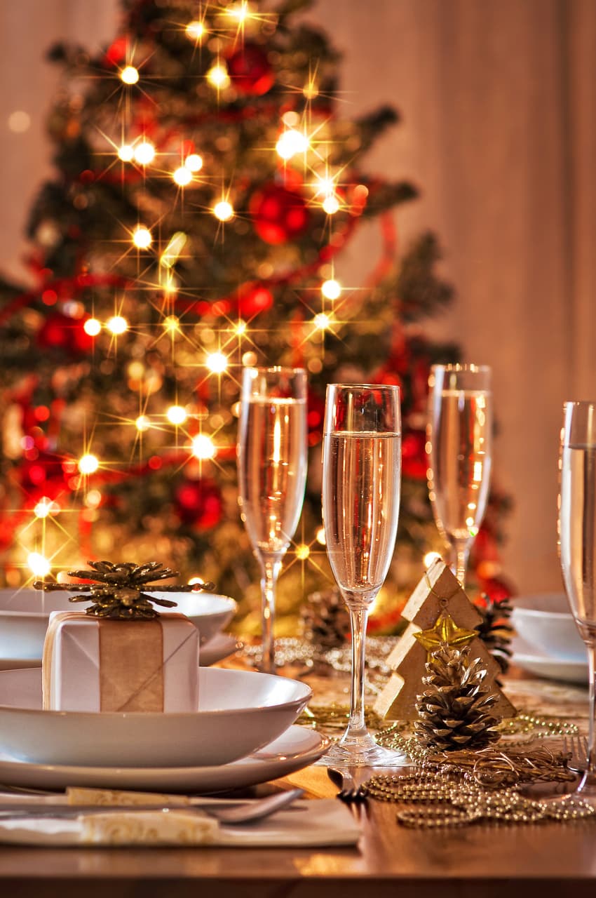 Champaign glasses on a table with christmas tree in the background.